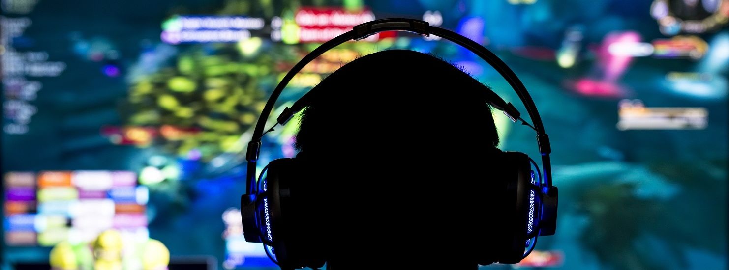 Young gamer playing video game wearing headphone.