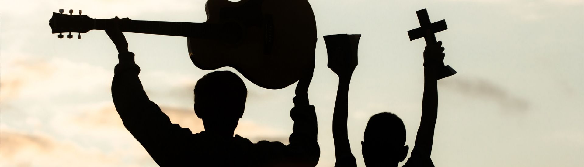 Two young christian worship God by holding cross and  with light sunset background,christian concept.