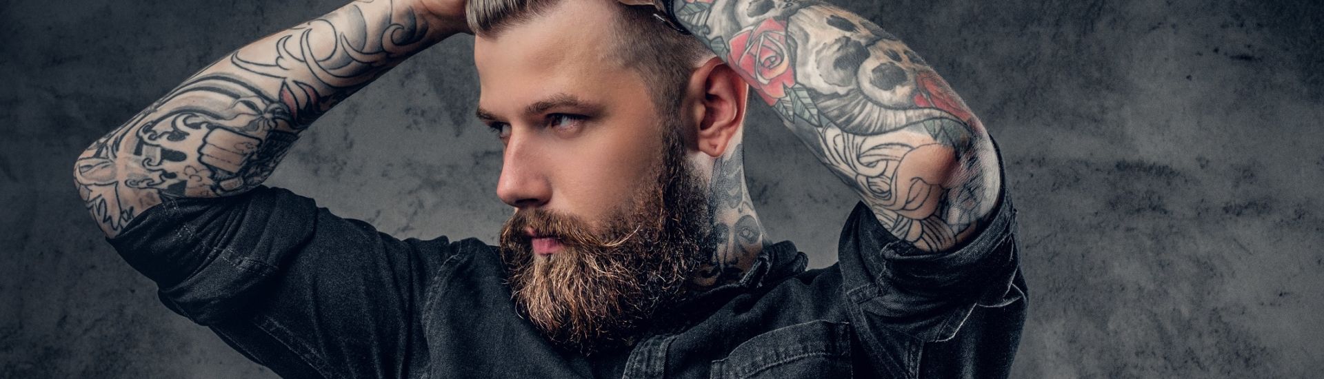 Studio portrait of bearded hipster man with tattoos.