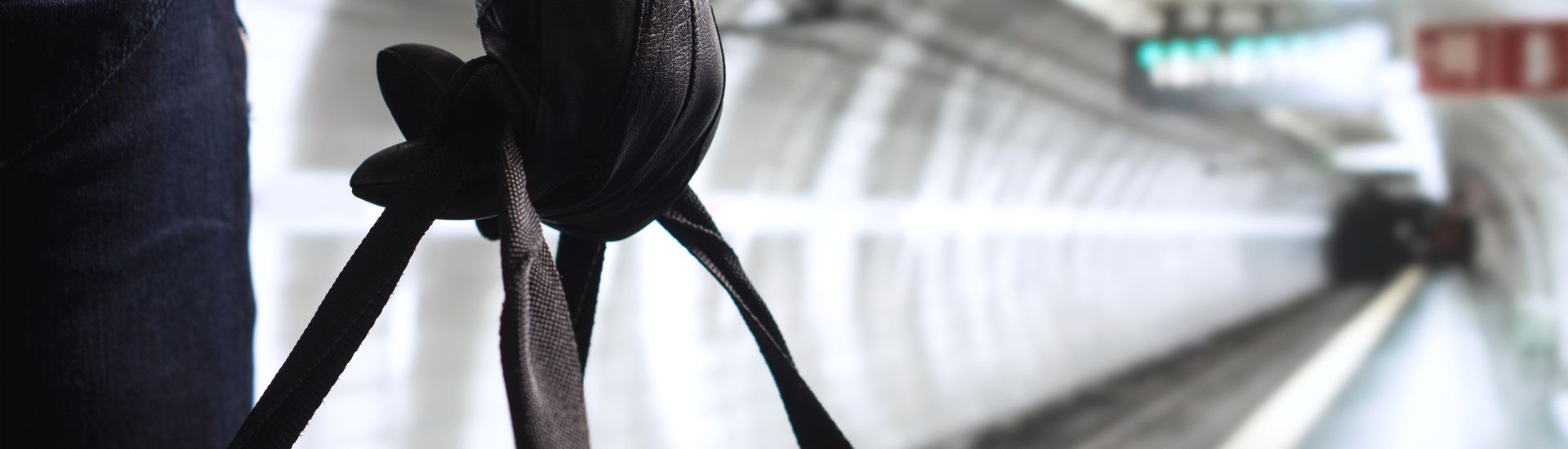 Terrorist in subway tunnel. Man planning bomb attack and strike in underground. Criminal standing in metro tunnel. Black bag and leather gloves. Security threat in public transportation concept.
