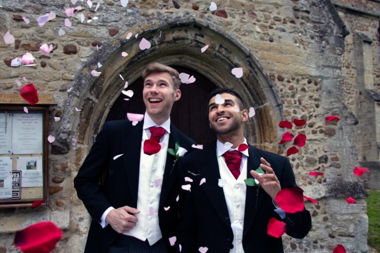 Gay wedding, grooms leave village church after being married to smiles and confetti