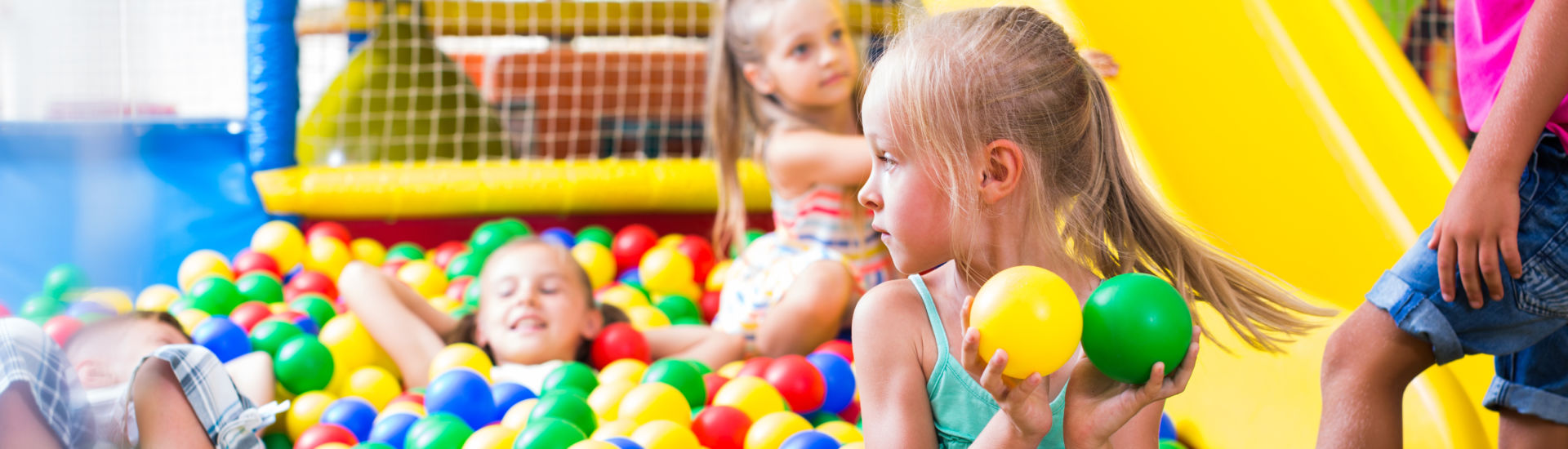 girl playing with multicolored plastic balls .