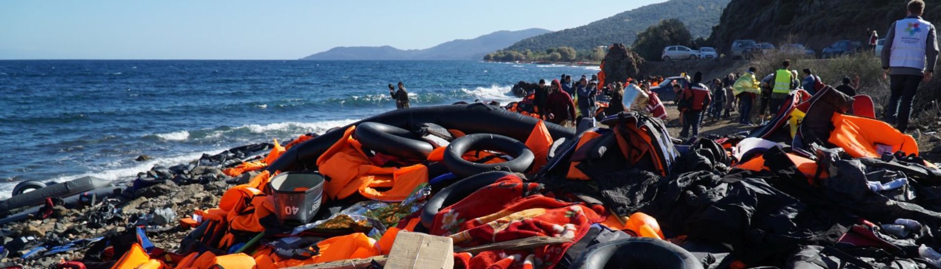 Abandoned belongings and life jackets on the shore
