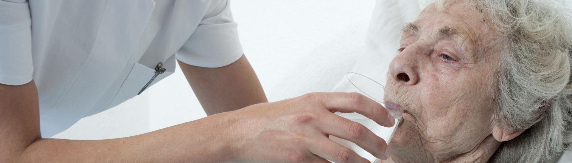 Altenpflegerin reicht wasserglas