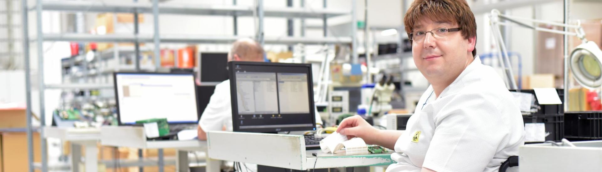 Rollstuhlfahrer am Arbeitsplatz in einer Fabrik zur Montage von Elektronik – Alltag mit Gehbehinderung // Wheelchair driver at the workplace in the industry