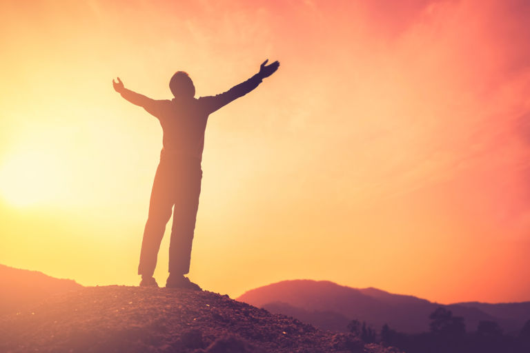 Copy space of man rise hand up on top of mountain and sunset sky abstract background.