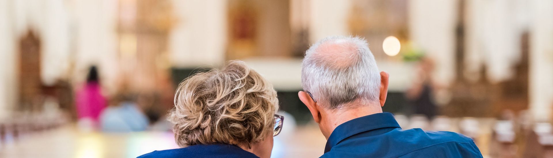 Back view of an elderly couple in the church, Madrid, Spain. Copy space for text.