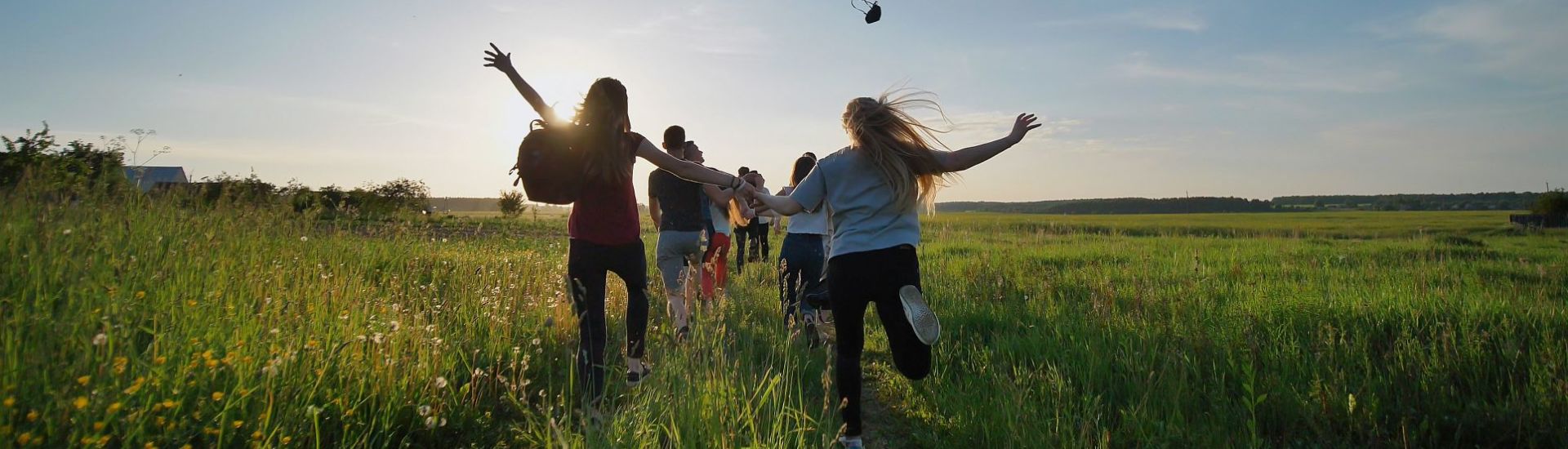 Happy senior pupils flee and toss their portfolios against the sunset. Happy ending school days. Slow motion.