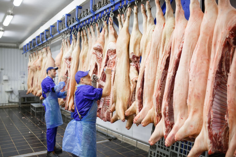 Butcher cutting pork  at the meat manufacturing.