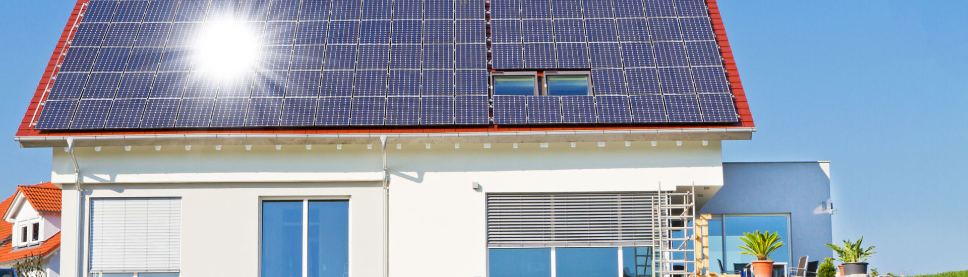 Haus mit Solarzellen und Sonne