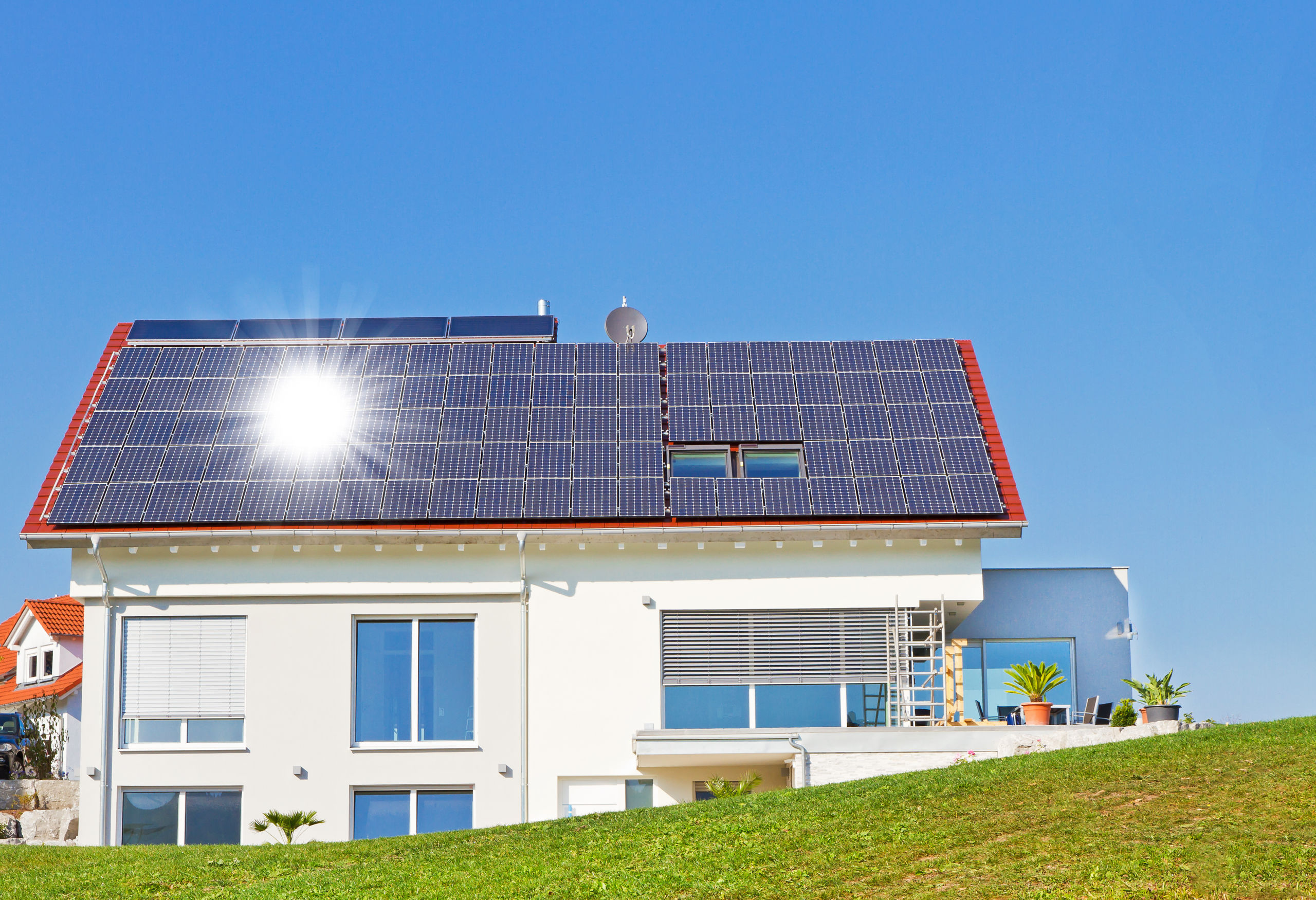 Haus mit Solarzellen und Sonne
