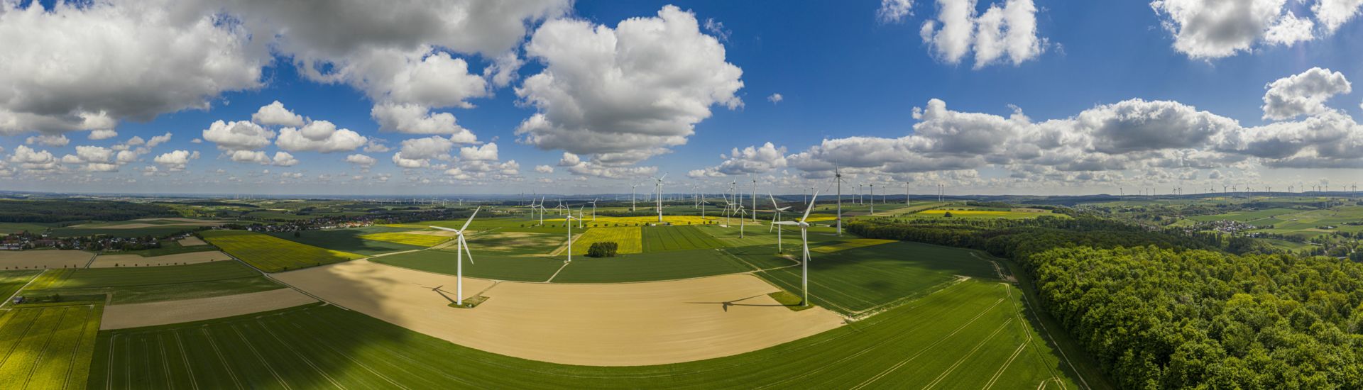 Panoramic aerial view over giant wind power field in Germany during daytime