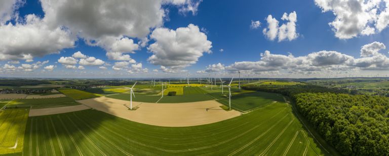Panoramic aerial view over giant wind power field in Germany during daytime