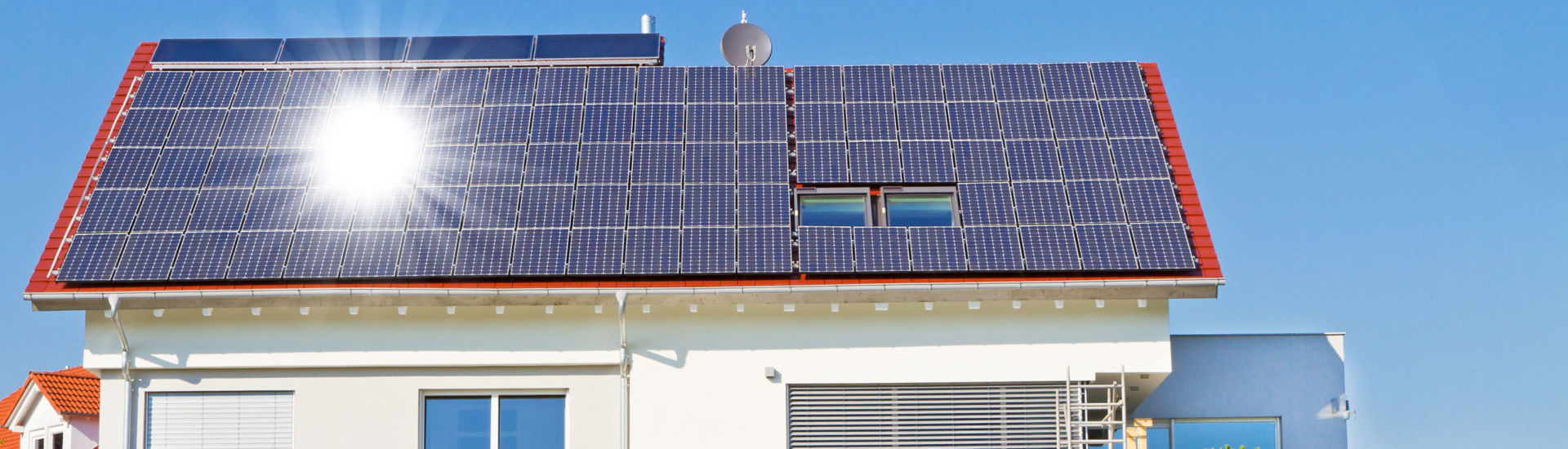 Haus mit Solarzellen und Sonne