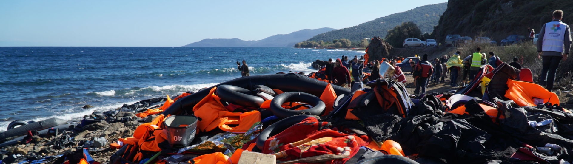 Abandoned belongings and life jackets on the shore