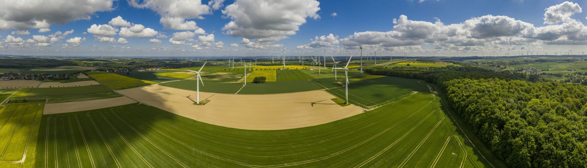 Panoramic aerial view over giant wind power field in Germany during daytime