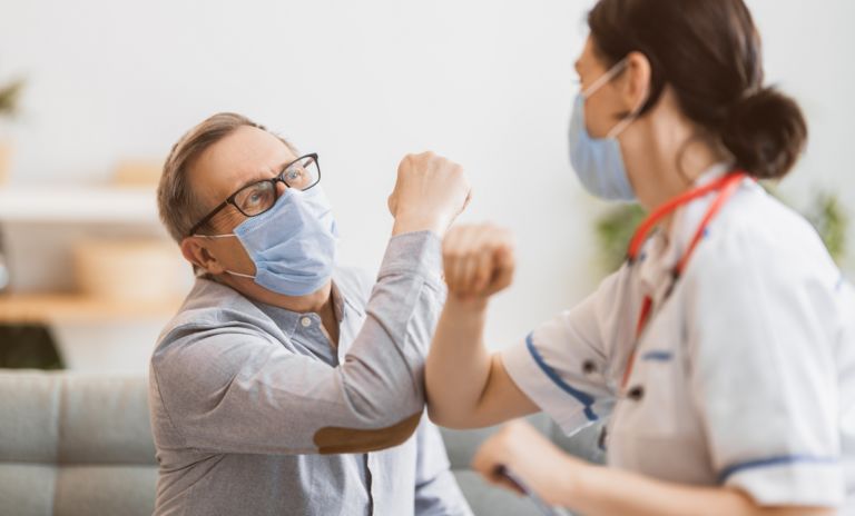 Doctor and senior man wearing facemasks