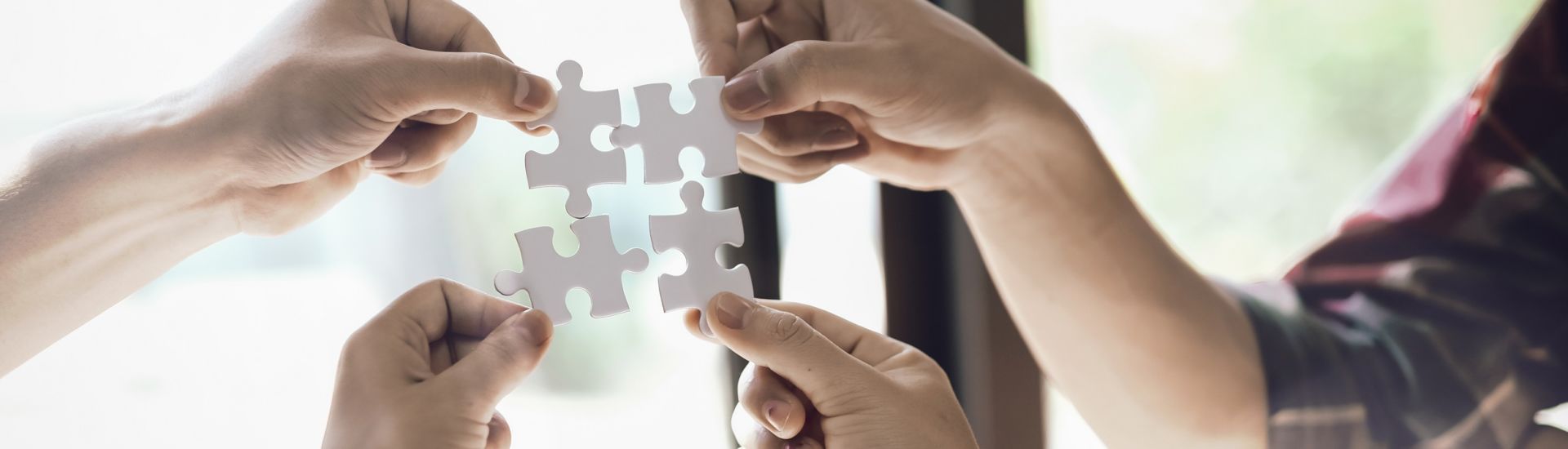Closeup hand of business people connecting jigsaw puzzle with sunlight effect, Business solutions and represent team support and help concept, success and strategy concept