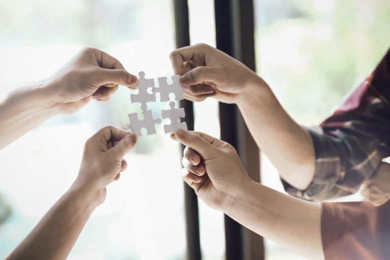 Closeup hand of business people connecting jigsaw puzzle with sunlight effect, Business solutions and represent team support and help concept, success and strategy concept