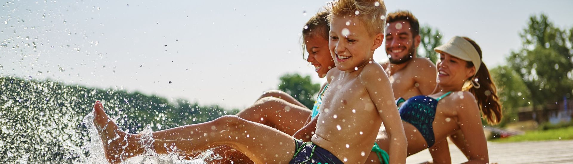 Familie hat Spaß und plantscht am Wasser