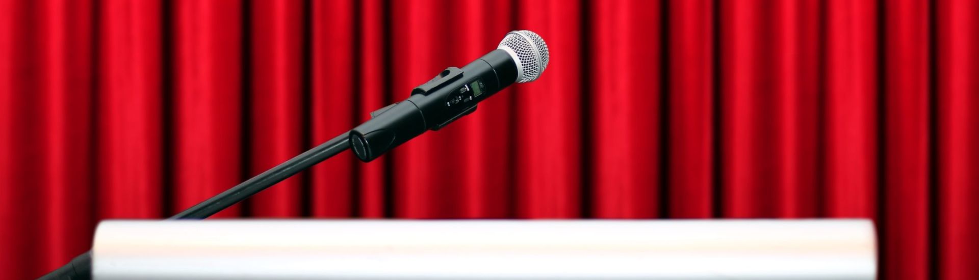 microphone on stage with red curtain background
