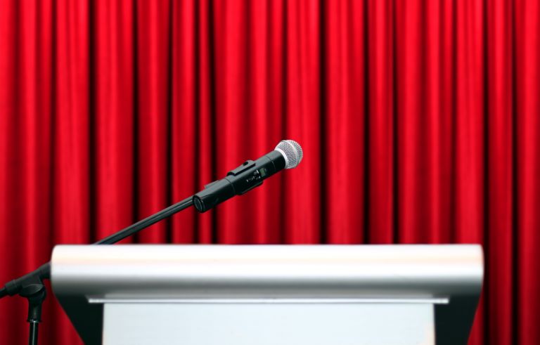 microphone on stage with red curtain background