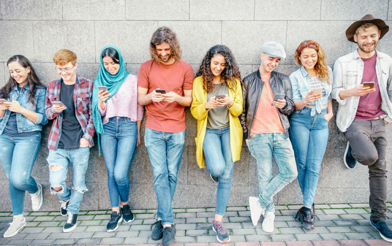 Group of fashion friends watching on their smart mobile phones – Millennial generation z addicted to new technology trends – Concept of people, tech, social media, friendship and youth lifestyle
