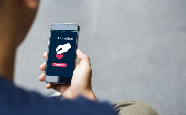 e-donation concept.close-up of man hands make an online donate v