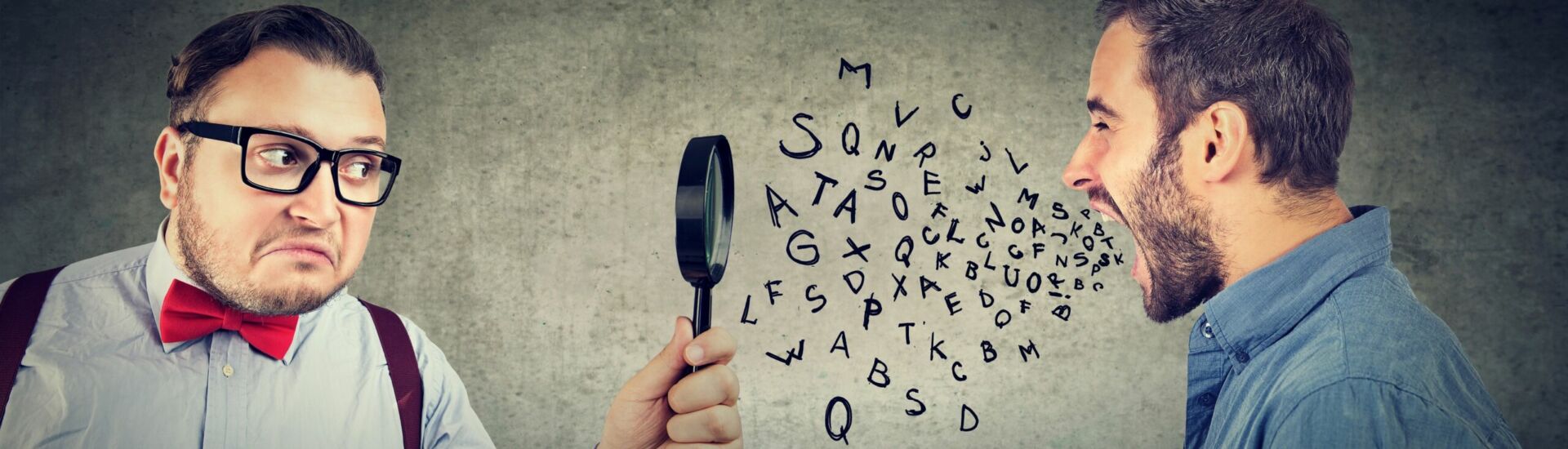 Curious businessman looking through a magnifying glass at an angry screaming man