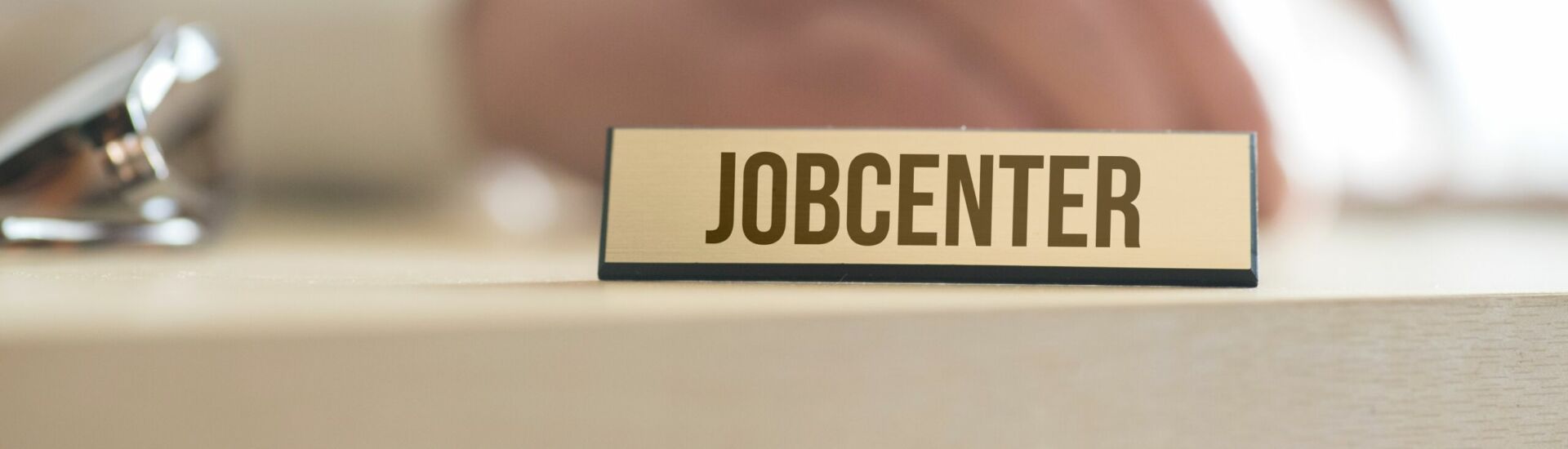 Ein Mann und ein Schild mit dem Aufdruck Jobcenter