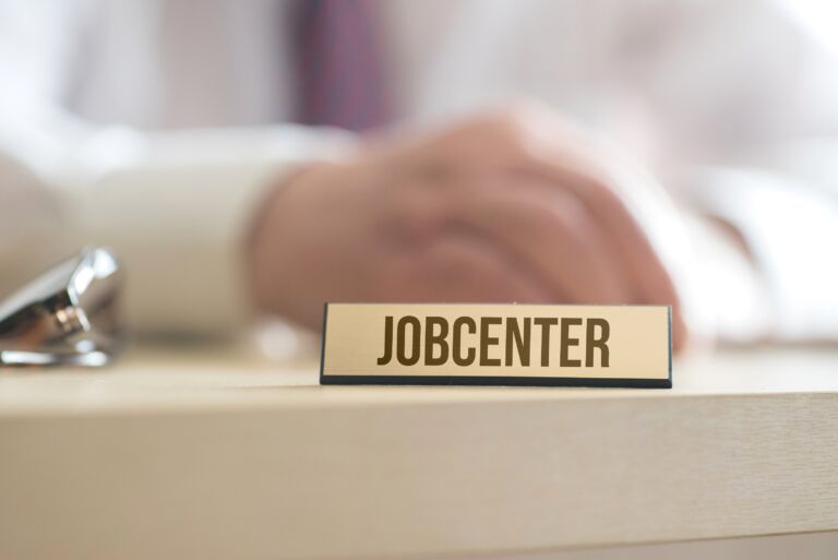 Ein Mann und ein Schild mit dem Aufdruck Jobcenter