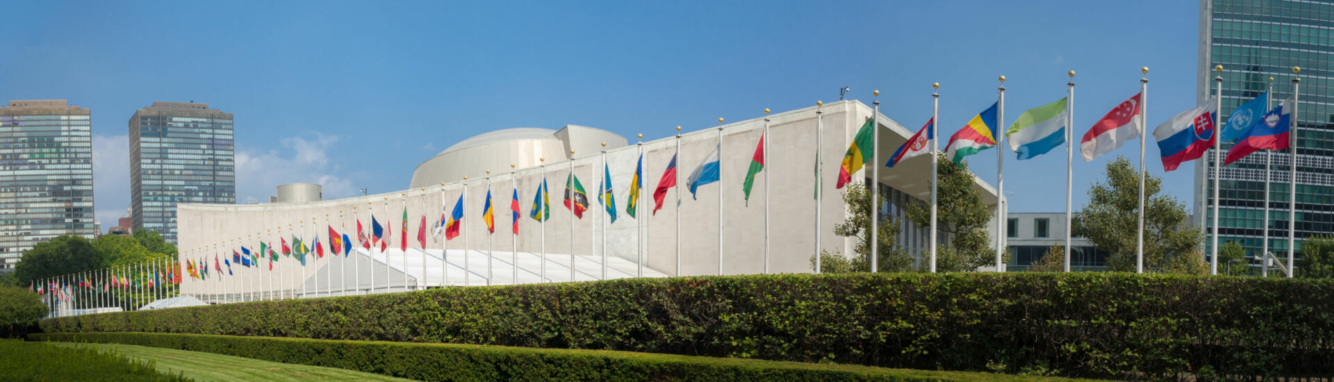 UN United Nations general assembly building with world flags fly