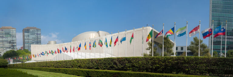 UN United Nations general assembly building with world flags fly