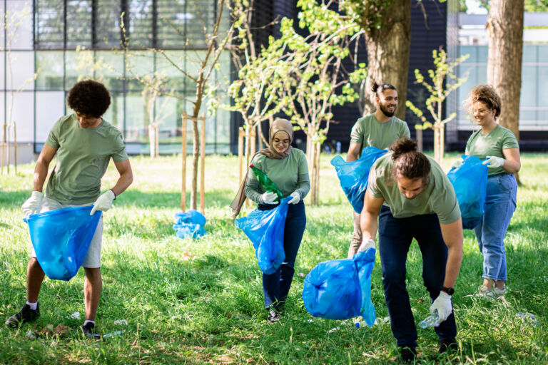 Multiethnic group of volunteers with garbage bags cleaning city