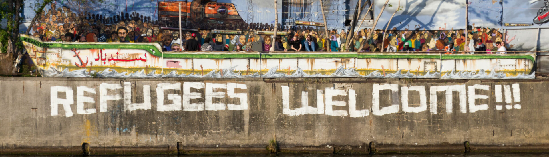Refugees welcome graffiti and refugee boat in Berlin