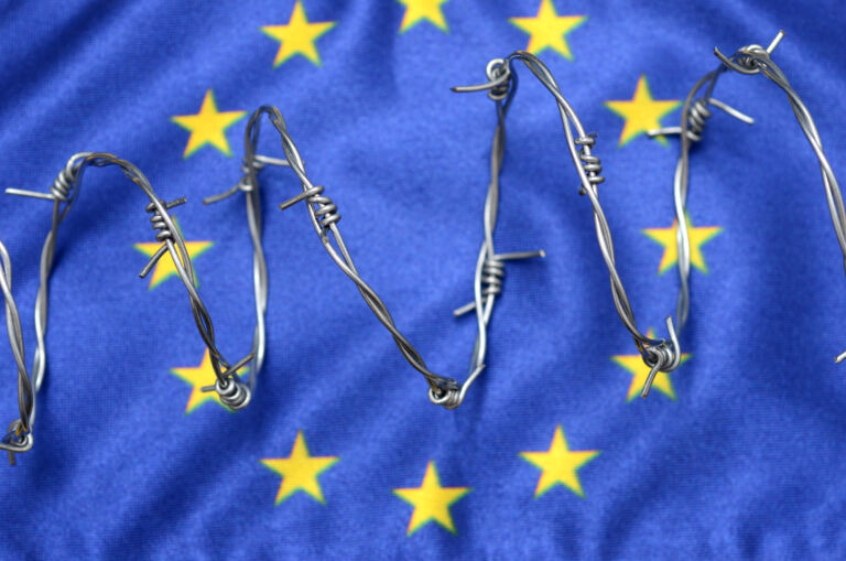European Union flag and barbed wire, migration to European Union concept