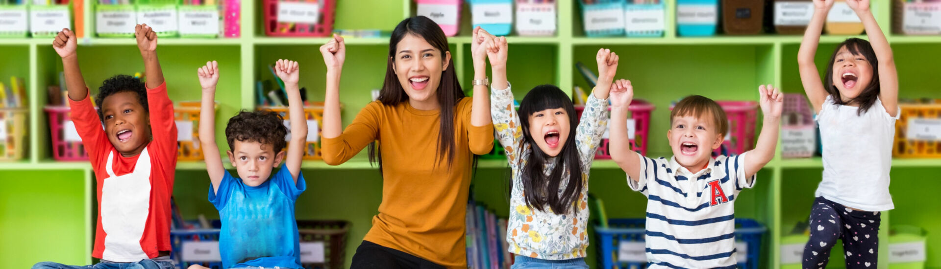 Happy Asian female teacher and mixed race kids in classroom,Kindergarten pre school concept.