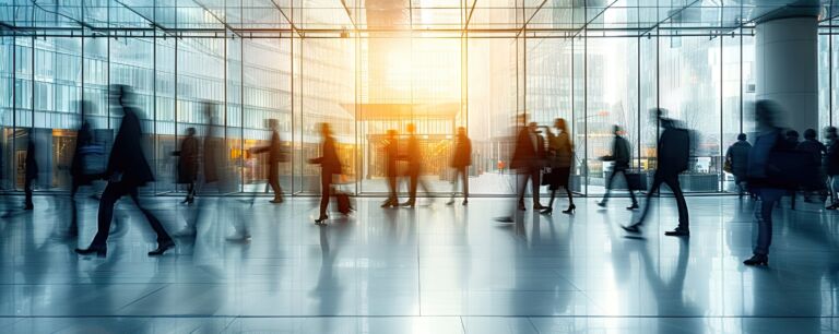 Busy businessmen and businesswomen walking in rush through modern city hall blurred motion in crowded urban fast lifestyle in business world ideal for concepts related to travel economy street life