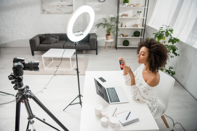 african american influencer holding hair straightener near digit