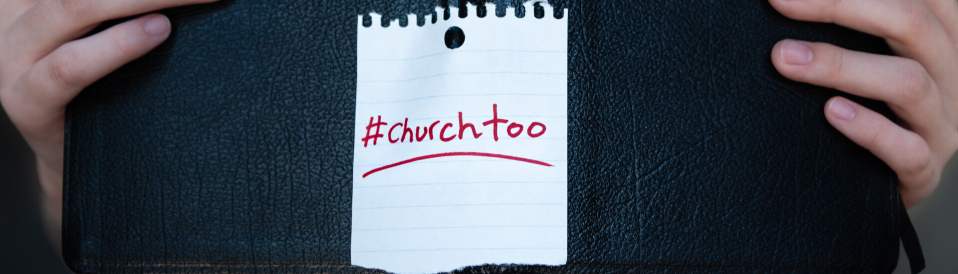 Woman holding Holy Bible with #churchtoo hashtag written on cover