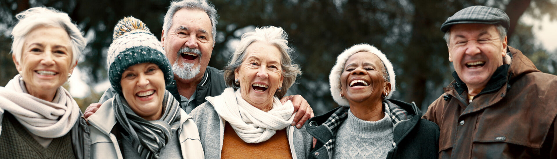 Happy, portrait and senior friends in a park while walking outdoor for fresh air together. Diversity, smile and group of elderly people in retirement taking picture and bonding in a forest in winter.