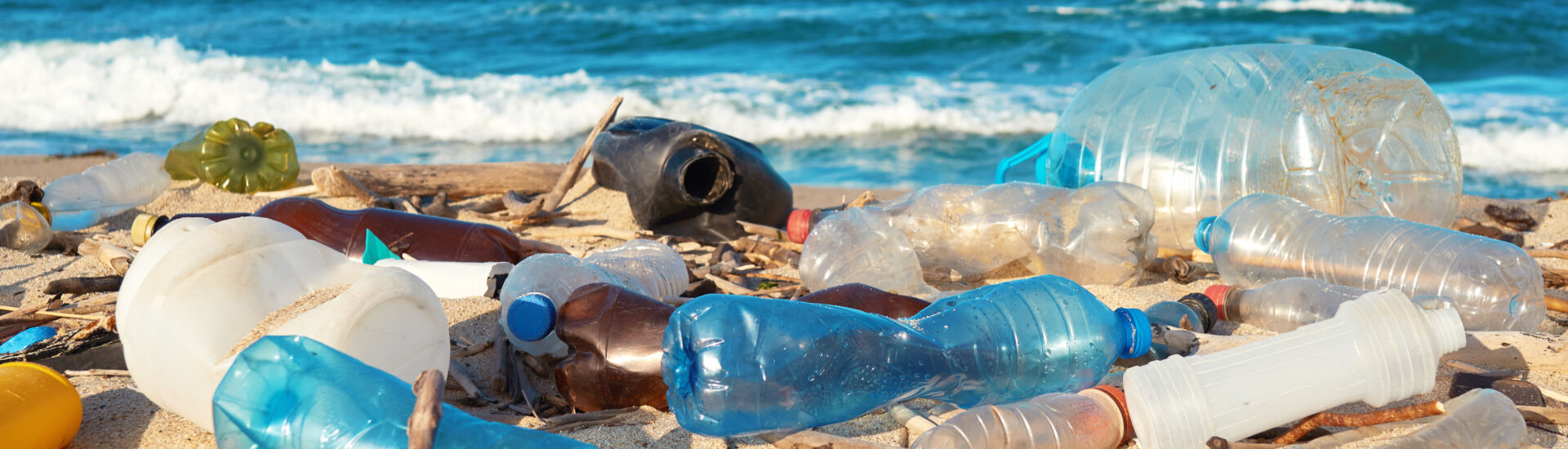 Spilled garbage on the beach of the big city. Empty used dirty p