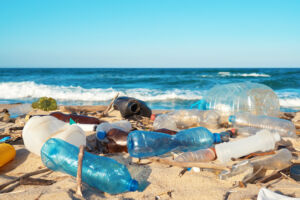 Spilled garbage on the beach of the big city. Empty used dirty p