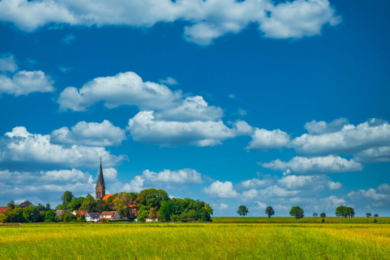 View over the fields to the village of Langwarden / Germany in Butjadingen