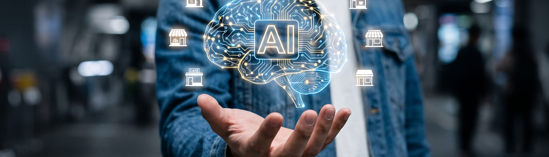 Artificial intelligence concept with a human hand holding glowing icons of small businesses and a brain illustration
